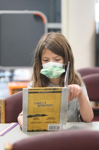 Student reading a book in class