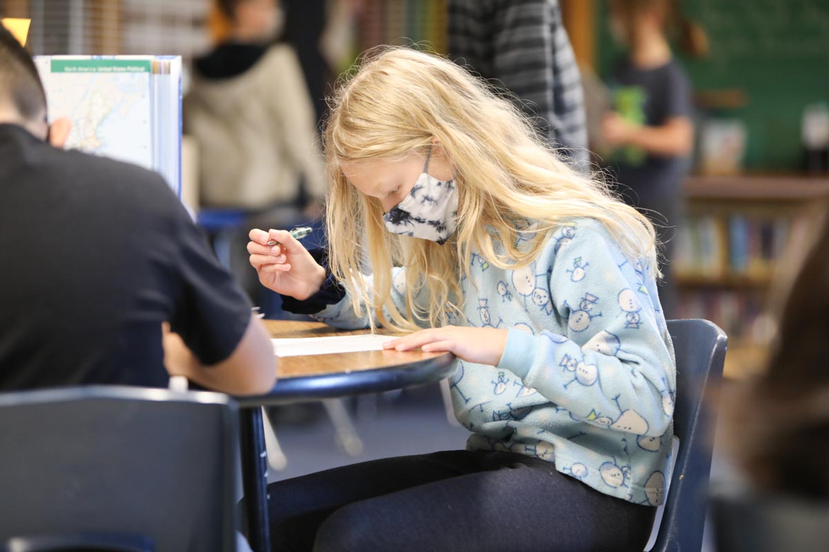 Student in class reading and writing